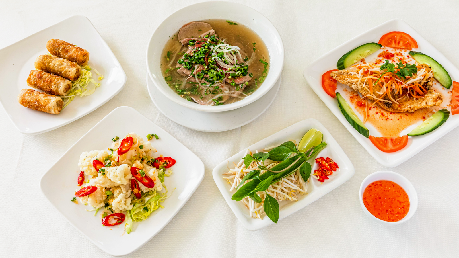 A spread of pho, summer rolls, caramelised fish and salt-and-pepper squid at Sông Quê